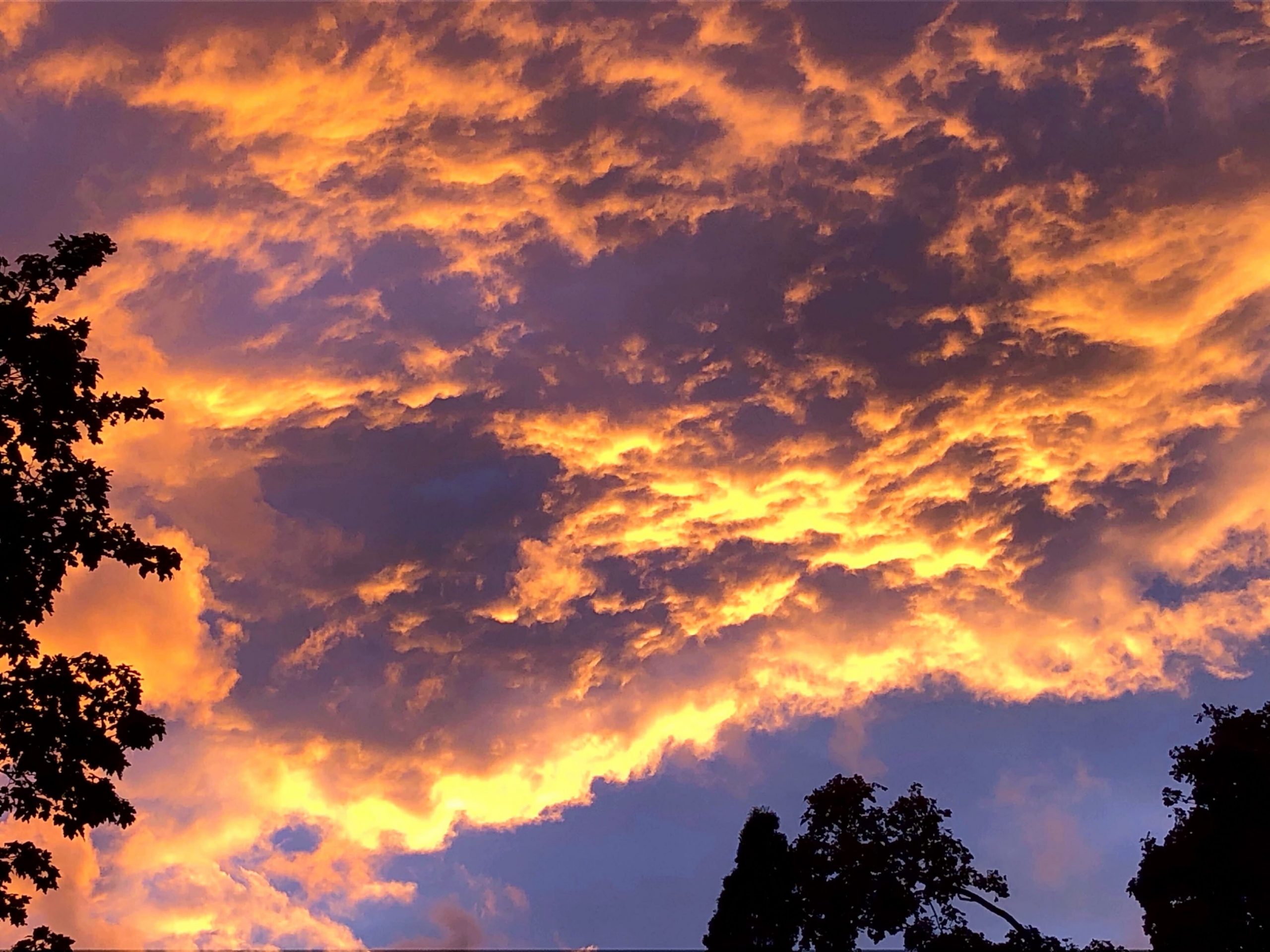 Bright cloudy sky during fiery sunset in summer or fall